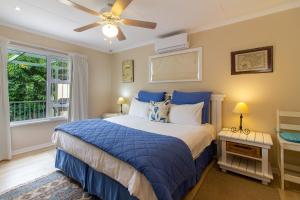 a bedroom with a bed and a ceiling fan at Dunwerkin Self Catering in Kenton on Sea