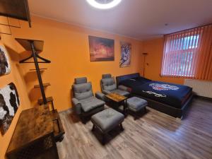a room with a bed and a couch and chairs at Penzion U Elišky in Liberec