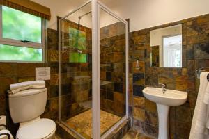 a bathroom with a shower and a toilet and a sink at Dunwerkin Self Catering in Kenton on Sea +39 photos