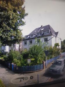 a white house with a fence in front of it at Stilvoll eingerichtete Altbauwohnung in Bremen