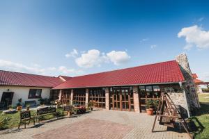 a building with a red roof and a patio at Winnica Mozów in Mozów