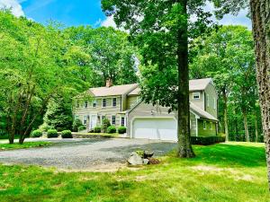 a house with a tree and a driveway at Upmarket Country Retreat, Washington, Connecticut in Washington