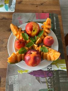 a plate of fruit and waffles and apples on a table at Chez Patrice et Marieline in Usson-en-Forez