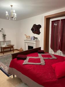 a bedroom with a bed with a red blanket at Chez Patrice et Marieline in Usson-en-Forez