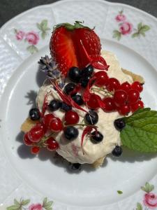 a dessert with berries and whipped cream and a strawberry at Chez Patrice et Marieline in Usson-en-Forez