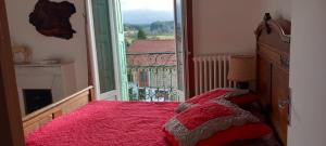 a bedroom with a bed with a pink blanket and a window at Chez Patrice et Marieline in Usson-en-Forez