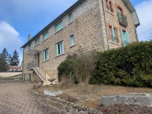 ein großes Backsteingebäude mit einem Fenster darauf in der Unterkunft Chez Patrice et Marieline F3 in Usson-en-Forez