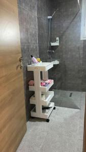 La salle de bains est pourvue d'un lavabo blanc et d'une douche. dans l'établissement Appartement T3 proche de la Plage !, à Jāmi‘ al Guelloufi