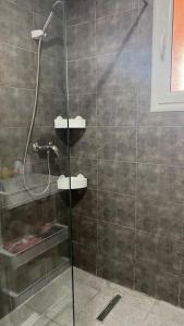 La salle de bains est pourvue d'une douche avec une porte en verre. dans l'établissement Appartement T3 proche de la Plage !, à Jāmi‘ al Guelloufi