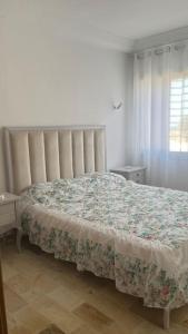- une chambre dotée d'un lit avec un couvre-lit floral dans l'établissement Appartement T3 proche de la Plage !, à Jāmi‘ al Guelloufi
