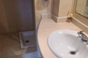 a bathroom with a white sink and a shower at Agadir Marina vue piscine in Agadir +16 photos