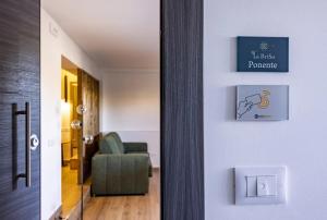 a hallway with a chair and a sign on a wall at La BriSa in Capo dʼOrlando