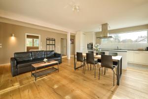 a living room with a black leather couch and a table at GOOD NIGHT Apartments in Basel