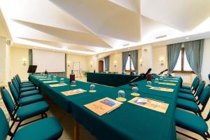 una sala de reuniones con mesas largas y sillas azules en Hotel La Bussola, en Amalfi