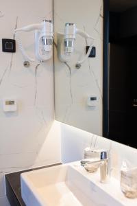 ein Badezimmer mit Waschbecken und Spiegel in der Unterkunft Avenue21 in Zagreb + 37 Fotos