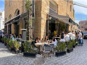 a group of people sitting at tables outside a restaurant at Batroun boutique suites in Batroûn