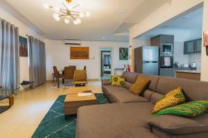 a living room with a couch and a table at The Avery Apartments, Dzorwulu in Accra
