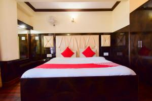 a bedroom with a large bed with red pillows at Hotel Shubham in Shimla