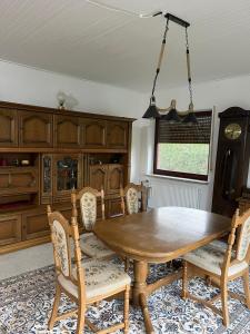 comedor con mesa de madera y sillas en Ferienhaus Heiderose, en Schneverdingen