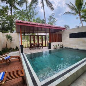 a swimming pool with a deck and a pavilion at Nalendro Villa Borobudur in Borobudur