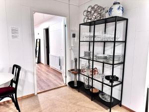 Langahlíð Guesthouse - Privatete Forest - في هيلاّ: رف أسود مع أطباق في غرفة
