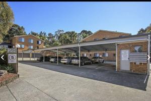 a parking lot with cars parked in a building at Dunes Holiday Apartment Unit 8 in Coffs Harbour