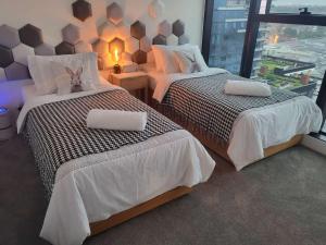 two beds in a room with a window at Modern&cozy life in Sky Garden 5min from station in Glen Waverley