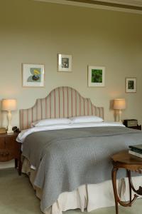 a bedroom with a large bed with a striped headboard at Ballyvolane House in Fermoy