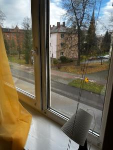 ein Fenster mit einem Stuhl und Straßenblick in der Unterkunft Ubytovaní U Dvora in Bohumín