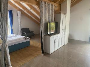 Un dormitorio con una cama y un televisor en una habitación. en Pension am Weberhof nur 20 Autominuten von München, en Ebersberg