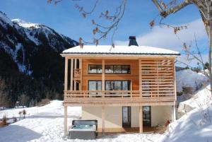 a wooden house in the snow in the mountains at Chalet Olbios in Peisey-Nancroix