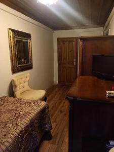 een slaapkamer met een bed, een bureau en een televisie bij EMİN EFENDİ KONAKLARI in Amasya