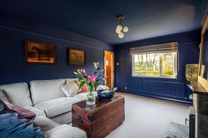 uma sala de estar com um sofá e uma mesa com flores em Hangley Cottage em Minehead