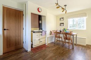 uma cozinha com uma mesa e uma sala de jantar em Hangley Cottage em Minehead