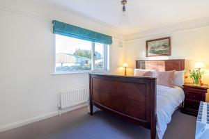 um quarto com uma cama grande e uma janela em Hangley Cottage em Minehead