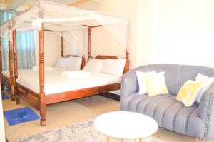 Roma Stays - Cozy 3 Bedroom Apartment with Swimming Pool in Shanzu في مومباسا: غرفة نوم مع سريرين بطابقين وأريكة +35 صورة