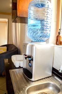 Roma Stays - Cozy 3 Bedroom Apartment with Swimming Pool in Shanzu في مومباسا: وجود زجاجة مياه فوق الميكروويف