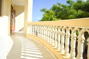 Roma Stays - Cozy 3 Bedroom Apartment with Swimming Pool in Shanzu في مومباسا: شرفة منزل مع سور أبيض