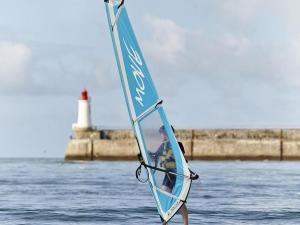 Appartement Les Sables-d'Olonne, 2 pièces, 2 personnes - FR-1-92-593 في لي سابلِ دولونْ: شخص على لوح شراع في الماء مع منور