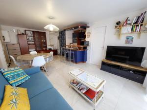 ein Wohnzimmer mit einem blauen Sofa und einem Tisch in der Unterkunft Appartement Les Sables-d'Olonne, 3 pièces, 4 personnes - FR-1-92-876 in Les Sables-dʼOlonne