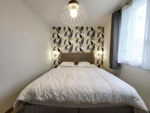 ein Schlafzimmer mit einem großen Bett mit einem Kronleuchter in der Unterkunft Appartement Les Sables-d'Olonne, 3 pièces, 4 personnes - FR-1-92-876 in Les Sables-dʼOlonne