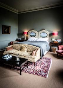 a bedroom with a bed and a couch in it at Ballyvolane House in Fermoy