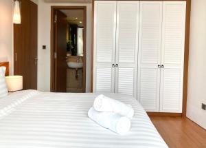 Un dormitorio con una cama blanca con toallas. en Vortex KLCC Apartment Kuala Lumpur en Kuala Lumpur