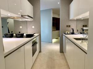 cocina grande con armarios y electrodomésticos blancos en Vortex KLCC Apartment Kuala Lumpur en Kuala Lumpur