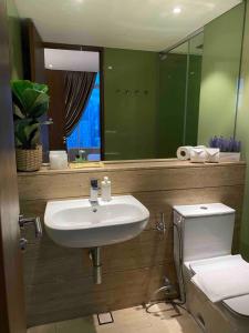 a bathroom with a sink and a toilet and a mirror at Vortex KLCC Apartment Kuala Lumpur in Kuala Lumpur