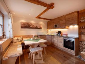 eine Küche mit einem Tisch und einem Herd in der Unterkunft Apartment-Chalet Mödlinghof in Hopfgarten im Brixental