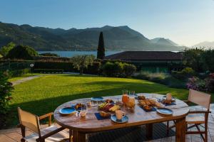 een houten tafel met eten op de top van een tuin bij Villa Margherita Portese in San Felice del Benaco
