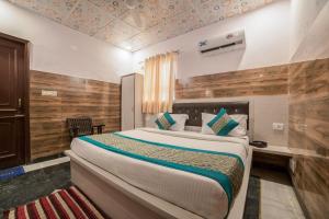1 dormitorio con 1 cama grande y escritorio en Collection O 13772 hotel krishna, en Noida