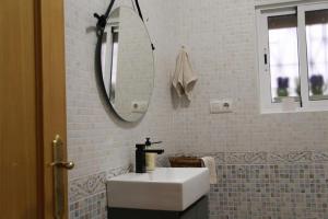 uma casa de banho com um lavatório branco e um espelho. em Las Cocheras del Marqués em Cehegín