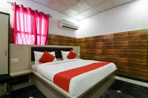 1 dormitorio con 1 cama grande con detalles en rojo en Collection O 13772 hotel krishna, en Noida